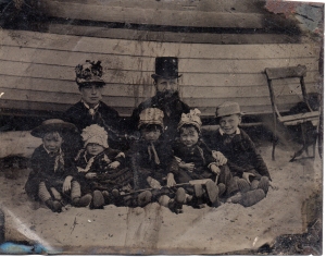 Family portrait at the seaside Unknown photographer Date unknown 6th plate tintype Sheila Masson Collection This image illustrates the incongruous outfits worn to the Victorian seaside compared with modern day beach attire: note the father's top hat juxtaposed with the hobnail boots on all of the children. 
